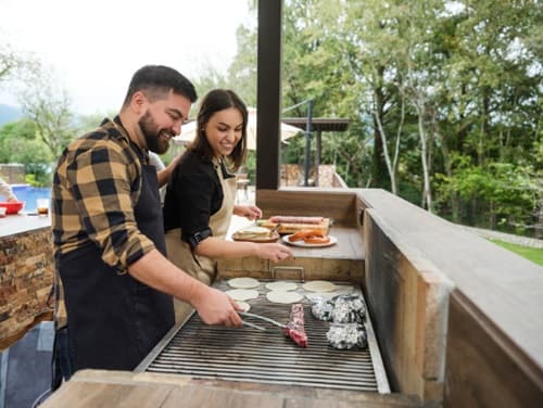Couple cuisinant au barbecue